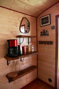 a room with wooden walls and shelves in a cabin at La Chouette Roulotte in Fresnay +13 photos
