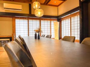 ein Konferenzraum mit einem großen Tisch und Stühlen in der Unterkunft 自然豊かな古民家豪邸 最大12名まで可 大人数に最適可で アクセス良好な 菱閣 in Fujikawaguchiko