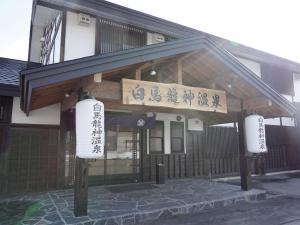 a building with chinese signs on the front of it at Hakuba Ryujin Onsen in Hakuba