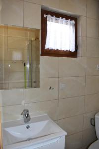 a bathroom with a sink and a shower and a window at Promyk in Sarbinowo +47 photos