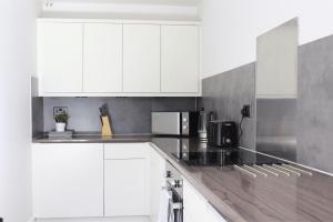 a white kitchen with white cabinets and appliances at 4 Bed House, MK Centre with Parking Contractor & Family Friendly in Haversham