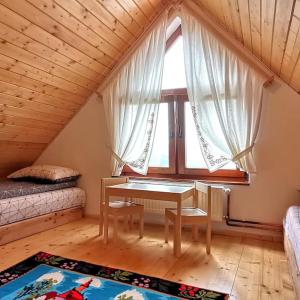 una camera con tavolo e finestra in mansarda di Casa din Cucă a Cornereva