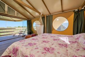 a bedroom with a bed and two mirrors at Suite Glamping vicino al mare in Piombino