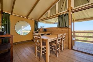 a dining room with a wooden table and chairs at Suite Glamping vicino al mare in Piombino
