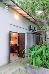 una entrada a una casa con un árbol en Baker's cottage, en Kosgoda