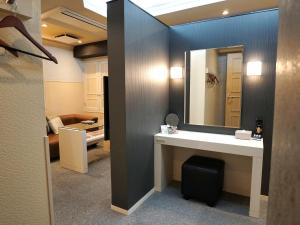 un bagno con lavandino e specchio di ホテルロイヤルトン a Okehasama