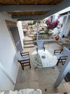 eine Terrasse mit Tisch und Stühlen und Treppe in der Unterkunft Case De Drymona 2 in Kýthira