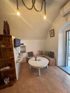 ein Wohnzimmer mit einem Tisch und einem Sofa in der Unterkunft Case De Drymona 2 in Kýthira