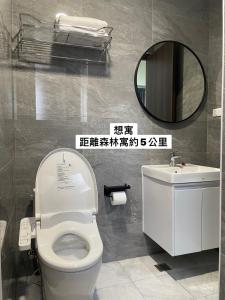 bagno con servizi igienici e specchio di 森林寓 a Minxiong