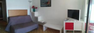 a bedroom with a bed and a desk and a tv at Carnon-plages - Agréable Studio cabine in Mauguio