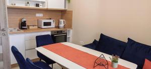 a small room with a table and blue chairs at Apartmenthaus Oborishte - 31 in Panagyurishte