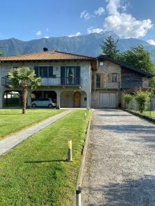 a house with a car parked next to a driveway at Casa Le Scese Porta di Valtellina in Piantedo