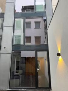 Un edificio con una gran ventana de cristal y un edificio en Triplex d'architecte en hypercentre, en Lieja