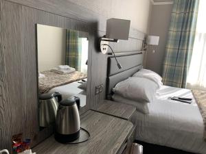a hotel room with a bed and a mirror at Hedley House Hotel & Apartments in York