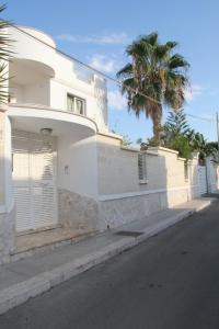 un edificio blanco con una palmera al lado de una calle en B&B Valentino, en Bari