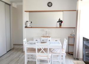 a dining room with a white table and chairs at L'Escale - centre-ville et plage in Roscoff