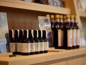 a row of bottles of wine on a shelf at Kanazawa Sainoniwa Hotel in Kanazawa