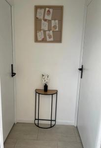 a room with two doors and a table with a picture at Le rafale Proche aeroport et Parc Exposition in Le Bourget