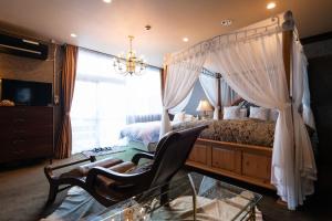 um quarto com uma cama de dossel com uma cadeira e uma janela em オーベルジュ天空 em Daisen