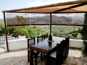 a wooden table with chairs and an umbrella on a patio at Casa Miguel Montefrio in Granada