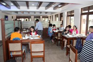 a group of people sitting at tables in a restaurant at Hotel Everest Nepal in Kathmandu
