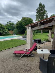 a patio with a chair and a grill and a table at Damvix Chambre d hôtes La Barbée in Damvix +4 photos