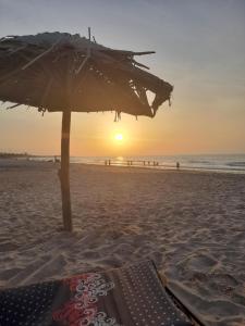 an umbrella on the beach with the sun setting at flowerhouse Sukuta Gambia in Sukuta