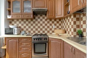 Una cocina con gabinetes de madera y un horno de estufa. en Komfortowe Studio w Gdańsku dla czterech osób by Noclegi Renters, en Gdansk 14 fotos más