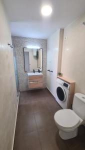 ein Badezimmer mit Toilette, Waschbecken und Spiegel in der Unterkunft Vista Mar Apartamento Playa Farnals in Playa Pobla de Farnals