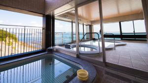 a house with a swimming pool and a balcony at Seaside Hotel Taimaru Kaigetsu in Naruto