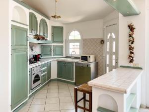 a kitchen with green cabinets and a counter top at Sardinia Summer Base in Gonnostramatza