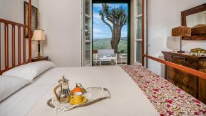 a bedroom with a bed with a tray of fruit on it at Principi di Butera 14, Emma Villas in Butera +40 photos