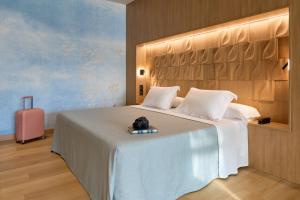 sypialnia z dużym łóżkiem i różową walizką w obiekcie Hotel Macià Doñana w mieście Sanlúcar de Barrameda