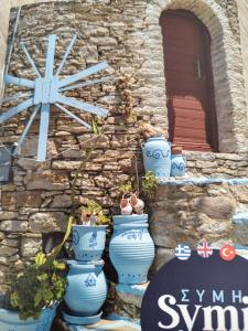 grupa niebieskich wazonów ustawionych przed kamiennym murem w obiekcie The Windmill w mieście Simi