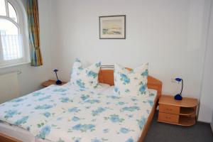 ヴァンガーオーゲにあるFerienwohnung Parkblick im Haus Nautilusの青い花柄のシーツと枕が備わったベッドのある寝室 +7枚の写真