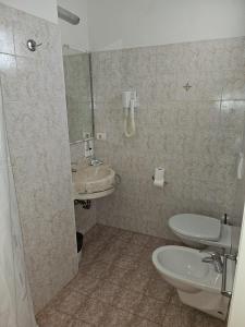 a bathroom with a toilet and a sink at Hotel Villa Rosa in Misano Adriatico