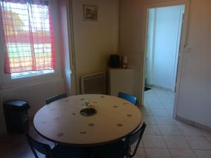 a dining room with a table and chairs and a window at location Vakañsoù in Lanouée