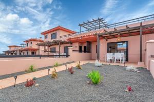 Casa con patio con mesa y sillas. en Villa Asensio, en Lajares