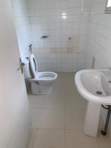 a white bathroom with a toilet and a sink at Chez saly in Saint-Louis +13 photos