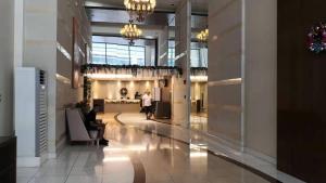 a lobby of a building with a person walking down it at Sunset House Roxas Bay in Manila