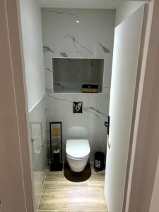 a bathroom with a white toilet in a room at le petit jurassien in Bellefontaine