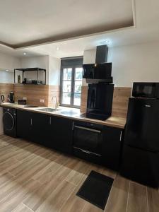 a kitchen with black cabinets and a counter top at le petit jurassien in Bellefontaine +2 photos