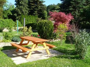 a wooden picnic table and bench in a garden at Ferienhaus Villa Maria - Ferienwohnung Chippendale in Kurort Gohrisch
