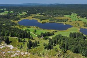 an aerial view of a golf course with two lakes at le petit jurassien in Bellefontaine