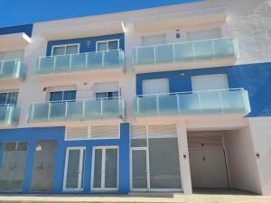 a blue and white building with a balcony at Nina's Blue Pool & Beach in Deltebre