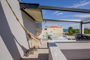 a hanging hammock on the balcony of a house at Морска къща ЕММА in Ofrínion