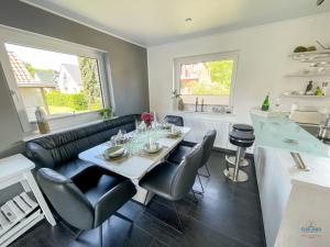 a living room with a table and some chairs at Ferienhaus Lindenweg Bad Bederkesa in Bad Bederkesa