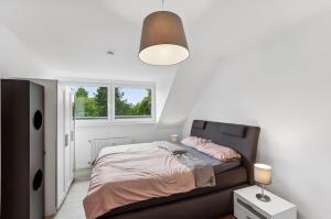 a white bedroom with a bed and a lamp at Aarper Boutique Apartment I Messe, Airport, Netflix & Forest in Düsseldorf