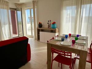 uma sala de estar com uma mesa de madeira e cadeiras vermelhas em Attico al Sovrano - Nel cuore della Puglia! em Turi mais 24 fotografias