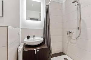 a white bathroom with a sink and a shower at Aarper Boutique Apartment I Messe, Airport, Netflix & Forest in Düsseldorf +7 photos